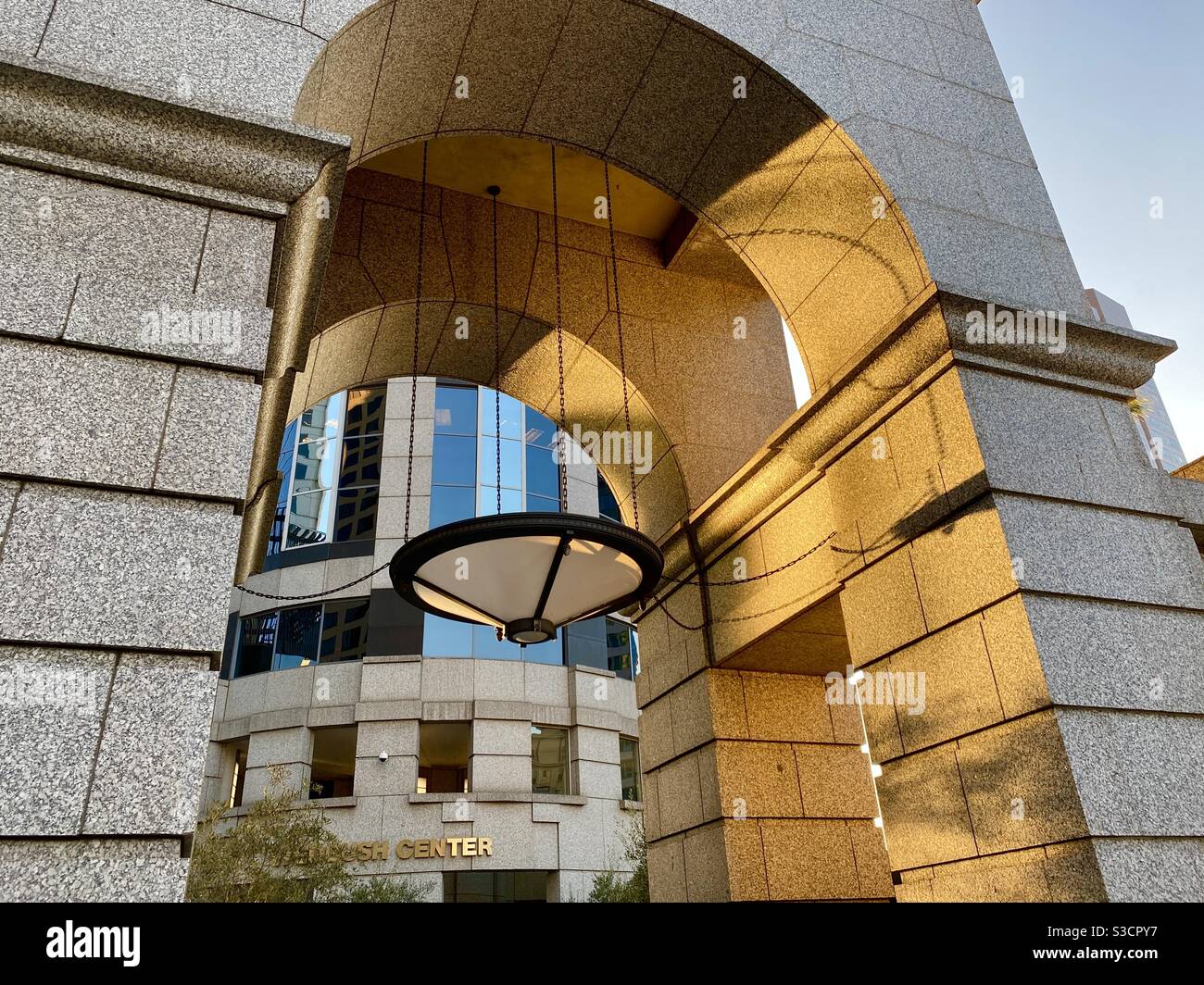 LOS ANGELES, CA, NOV 2020: detail of entrance arch at the Wedbush Building, illuminated by golden light from setting sun in Downtown - Smartphone Captured Stock Image