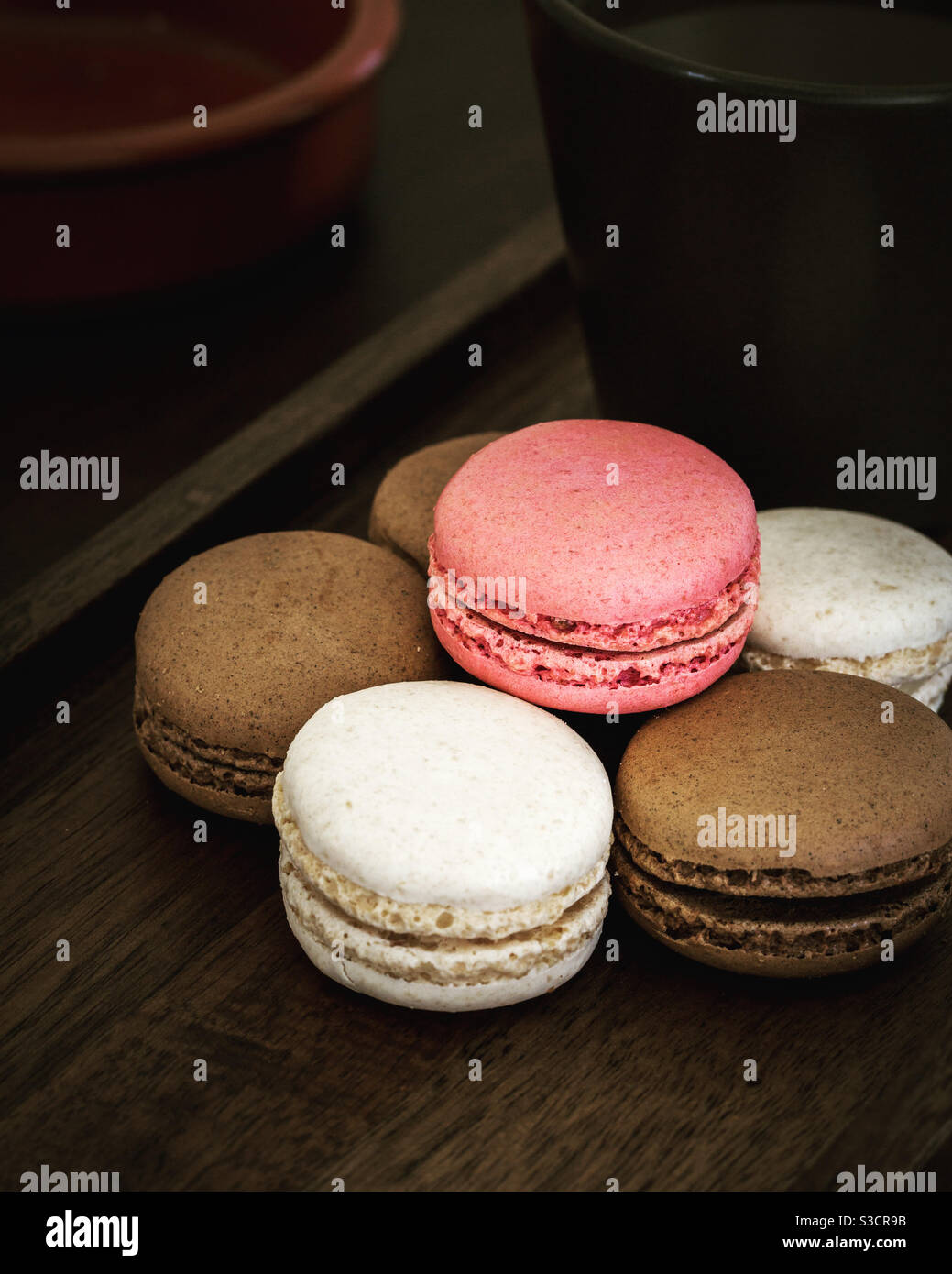 Delicious french patisserie macaroons with a hot cup of coffee as a sweet treat at break time - Smartphone Captured Stock Image