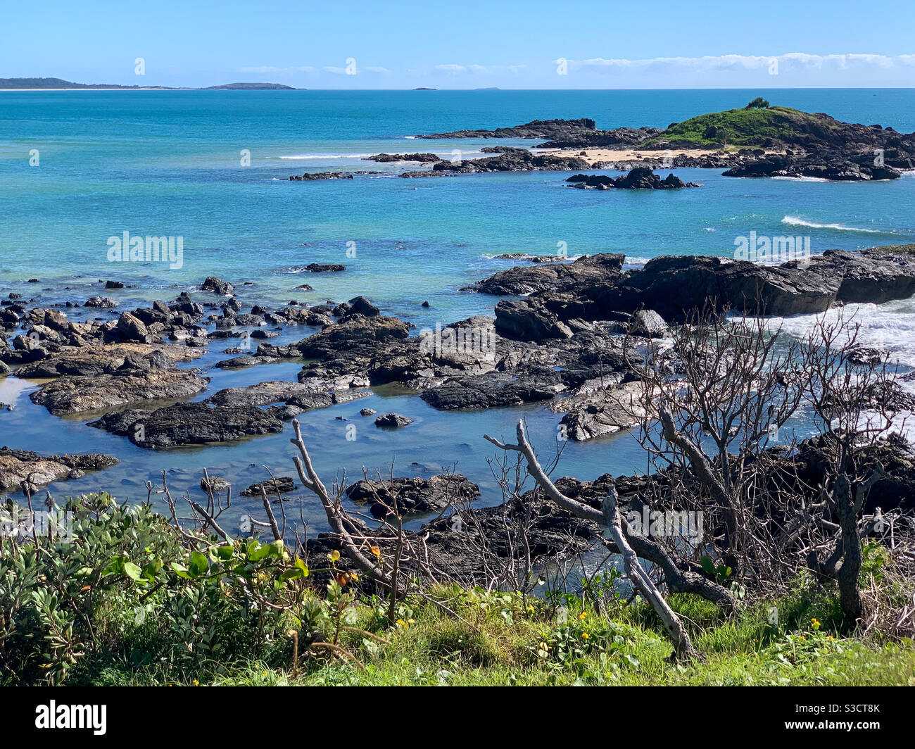 So many shades of blue in this Australian seascape of stunning blue Pacific Ocean, beaches, rock pools and green headland. coastline on a blue sky summers day - Smartphone Captured Stock Image