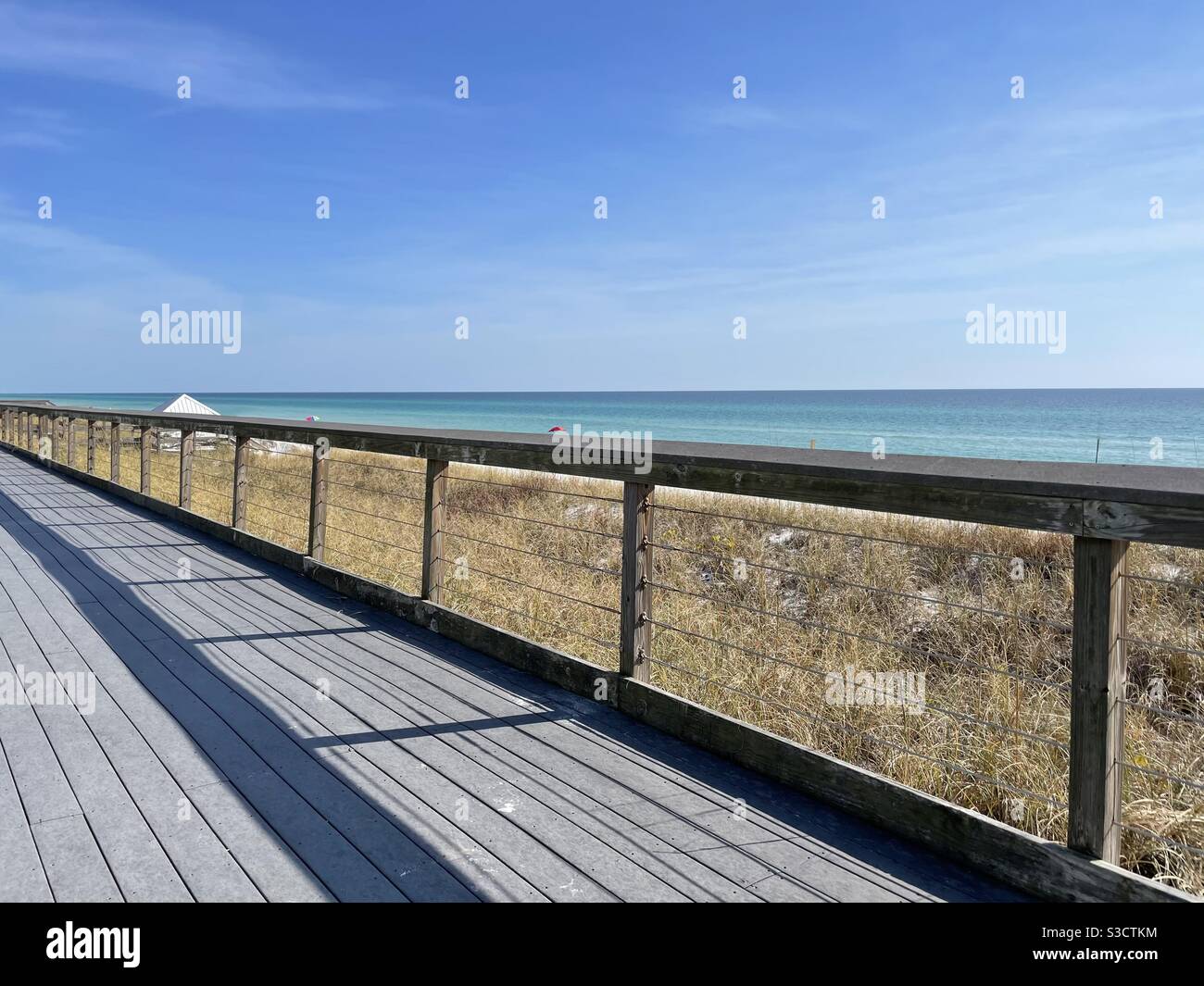 Walking path with views of emerald colored water in Miramar Beach Florida Stock Photo