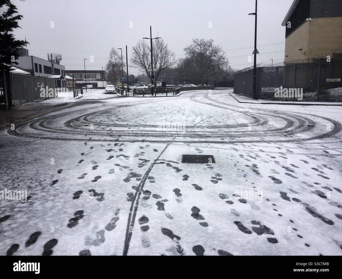 Footprints and tyre prints in light snow on an industrial estate in Tottenham, UK Stock Photo