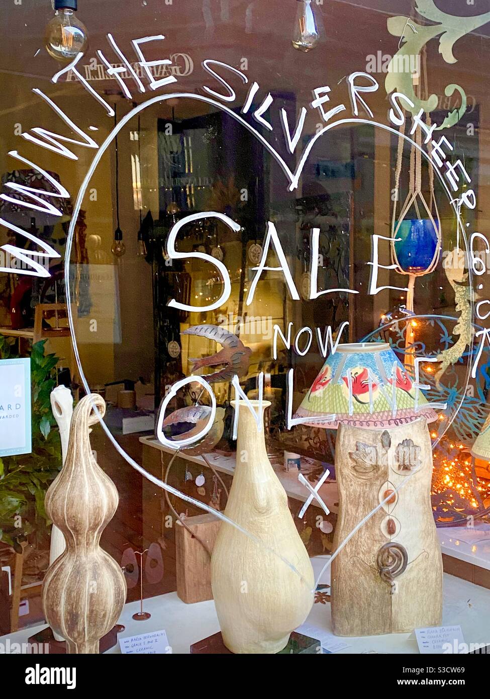 Shop Window situated in Chapel Place Tunbridge Wells England - promoting a SALE ONLINE of pottery and woollen garments during the 2019/2020 Pandemic Lockdown. Heart Valentine promotion via Internet. Stock Photo
