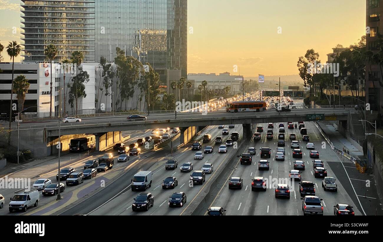 LOS ANGELES, CA, NOV 2020: looking south at traffic on the CA-110 freeway passing Downtown offices, hotels and apartments at sunset. Bus passing on bridge - Smartphone Captured Stock Image