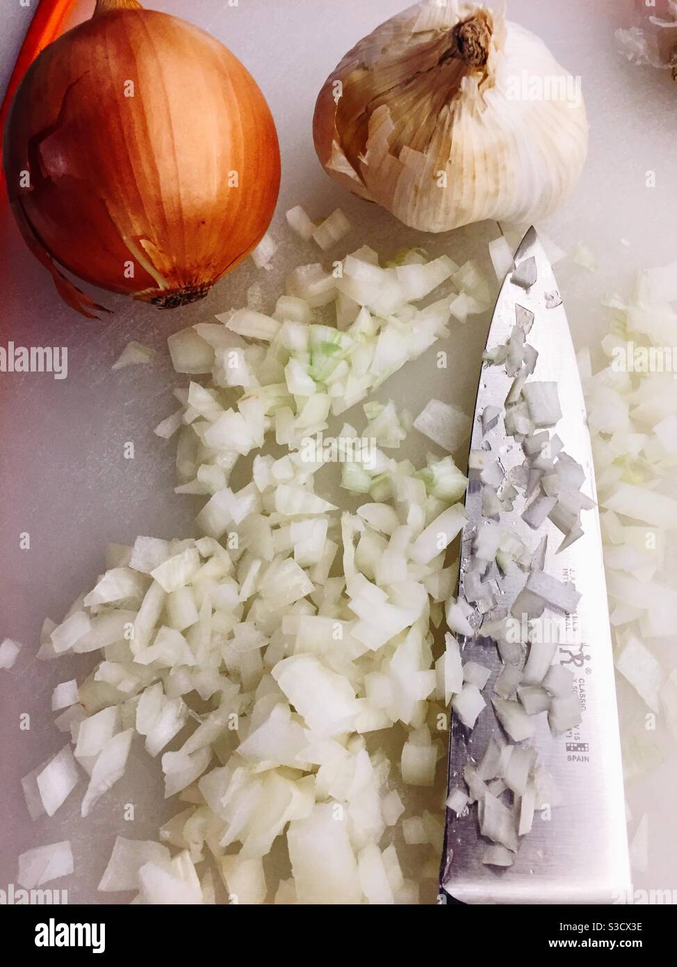 Freshly chopped onion and a large knife on a residential kitchen cutting board, USA - Smartphone Captured Stock Image