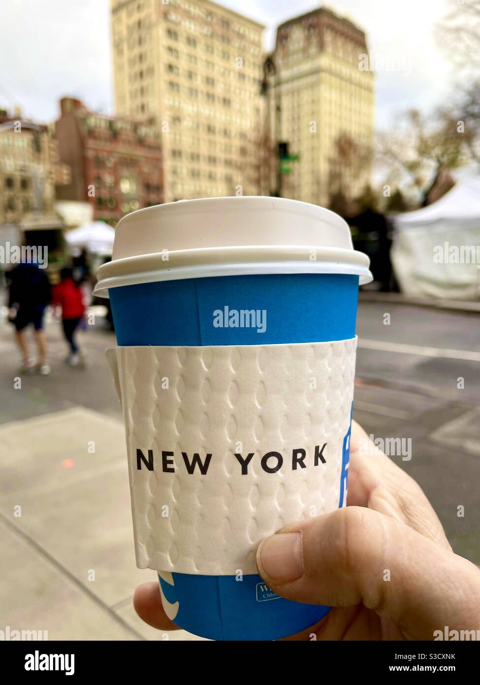 There’s nothing like a hot cup of coffee on a cold winter day as one strolls through the farmers market at Union Square in New York City, USA - Smartphone Captured Stock Image