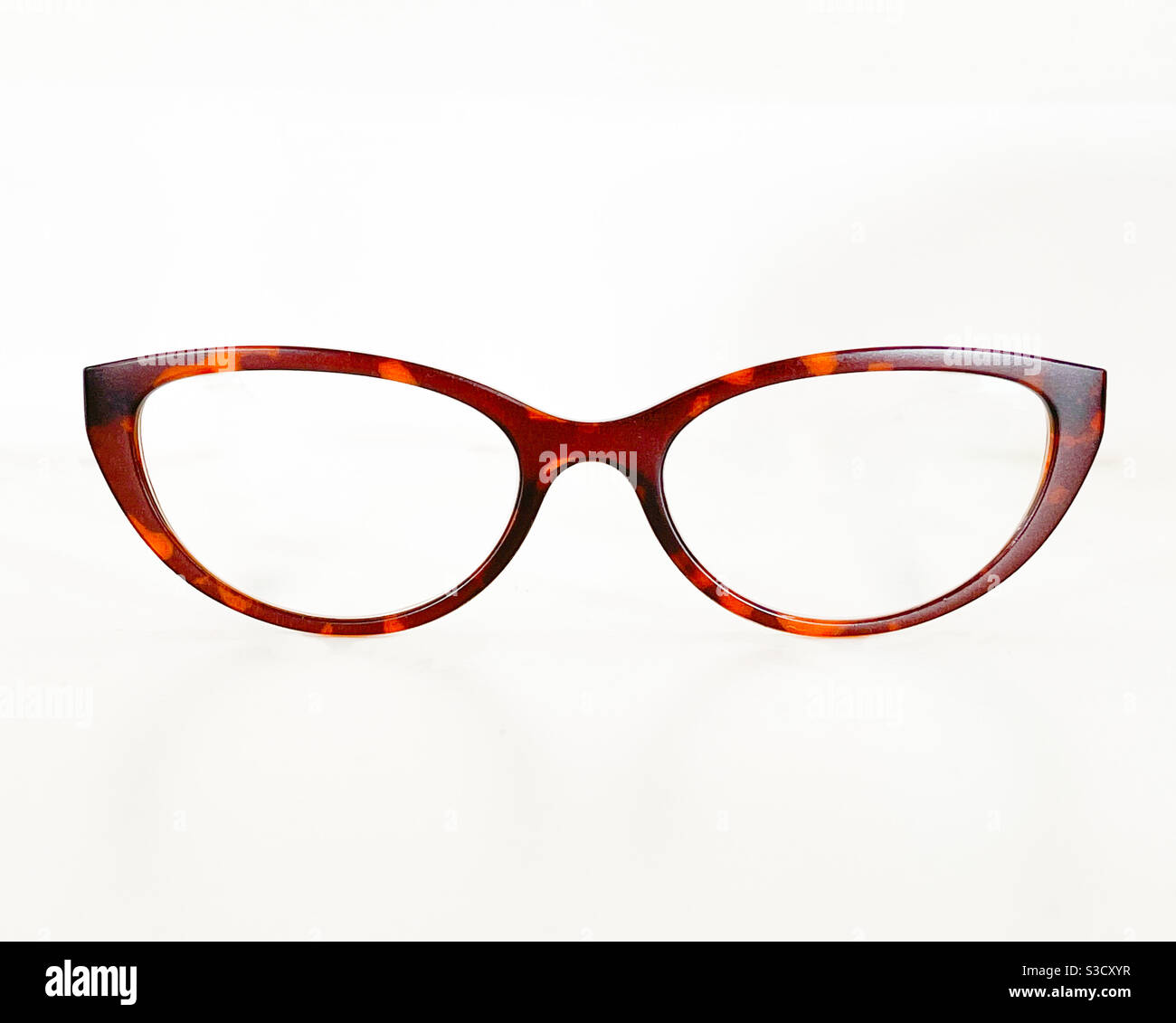 Front view of a pair of tortoiseshell colour glasses frames in a cats eye shape on a plain white background. No people. Copy space. Stock Photo