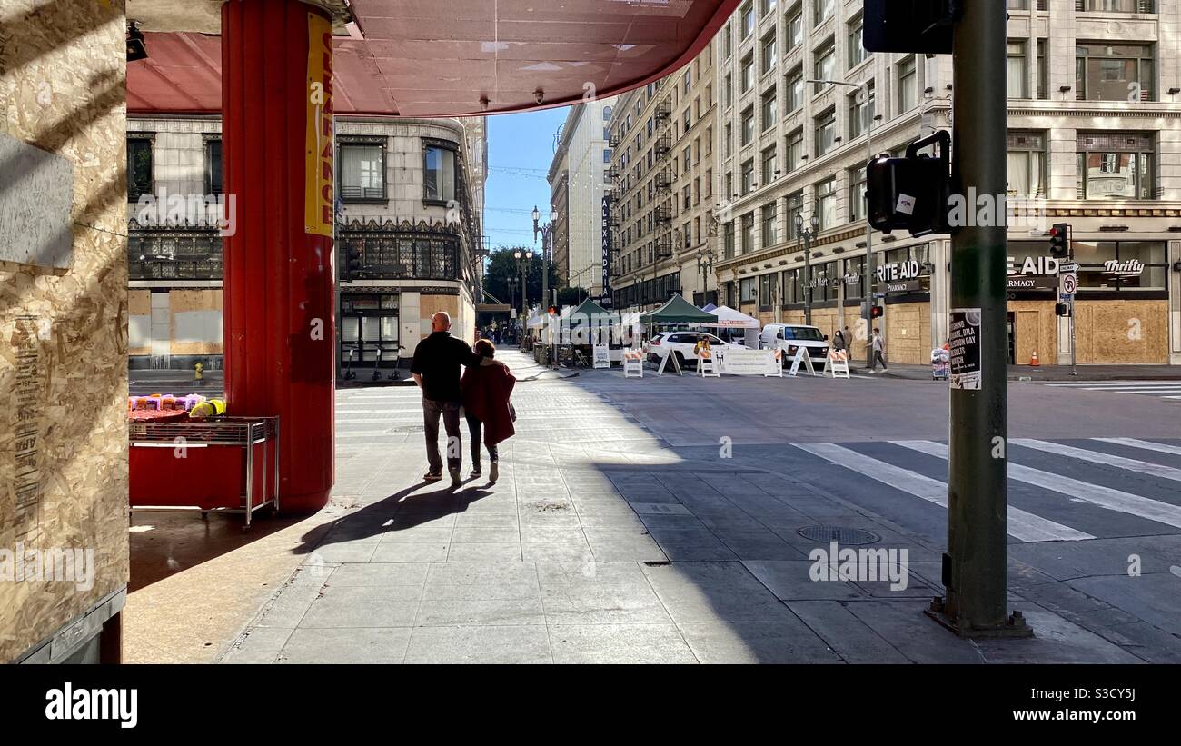 LOS ANGELES, CA, NOV 2020: silhouetted couple walking towards open air farmers market during Covid-19 pandemic in Downtown on a Sunday morning Stock Photo