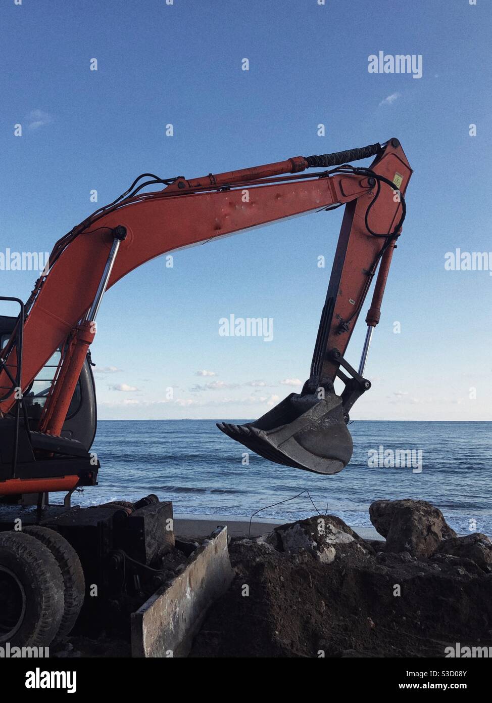 Excavator doing roadworks by the sea - Smartphone Captured Stock Image