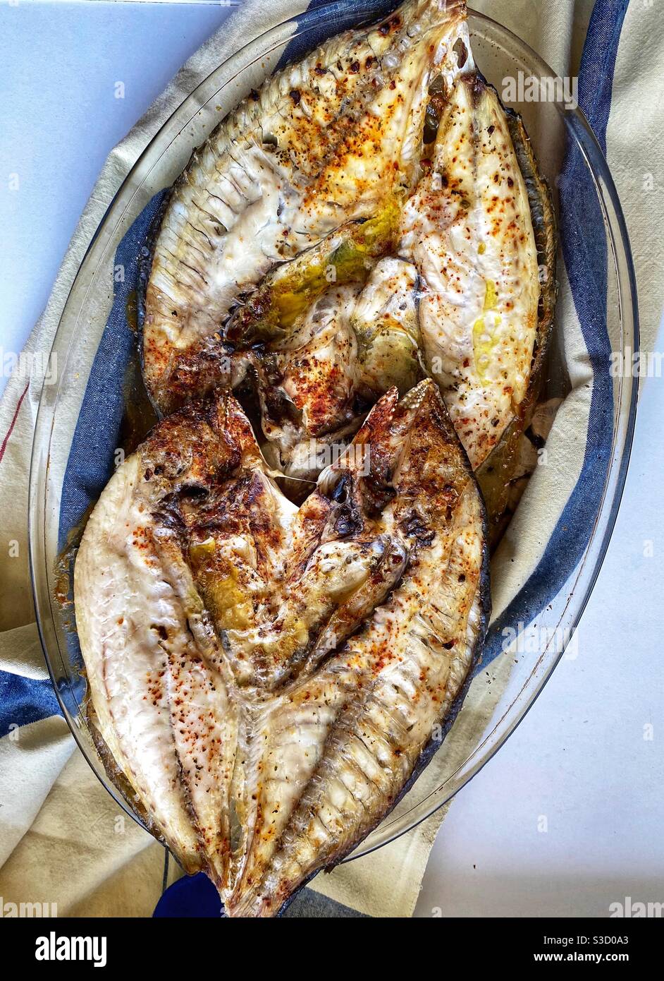 Two sea bream cooked with olive oil and spices Stock Photo