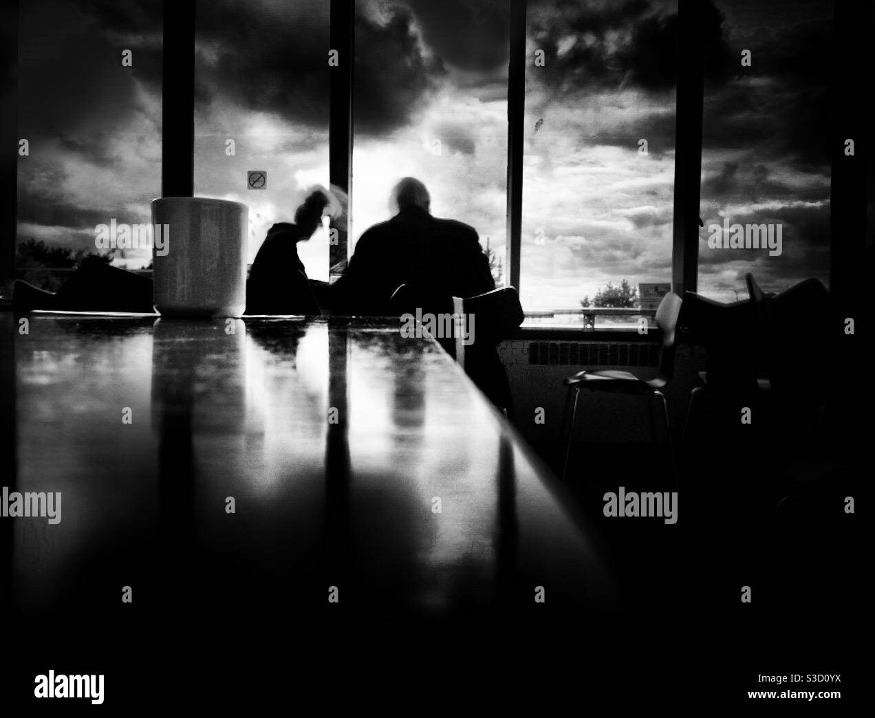 Elderly couple sit in front of a dramatic skyline Stock Photo