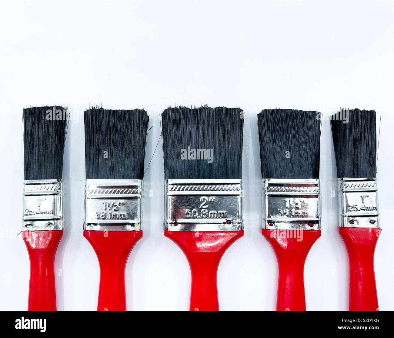Paint brushes of different sizes in a row isolated against a white