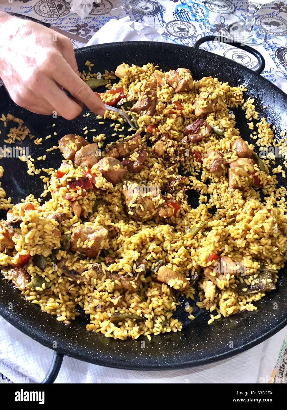 Person with a fork eating paella Stock Photo