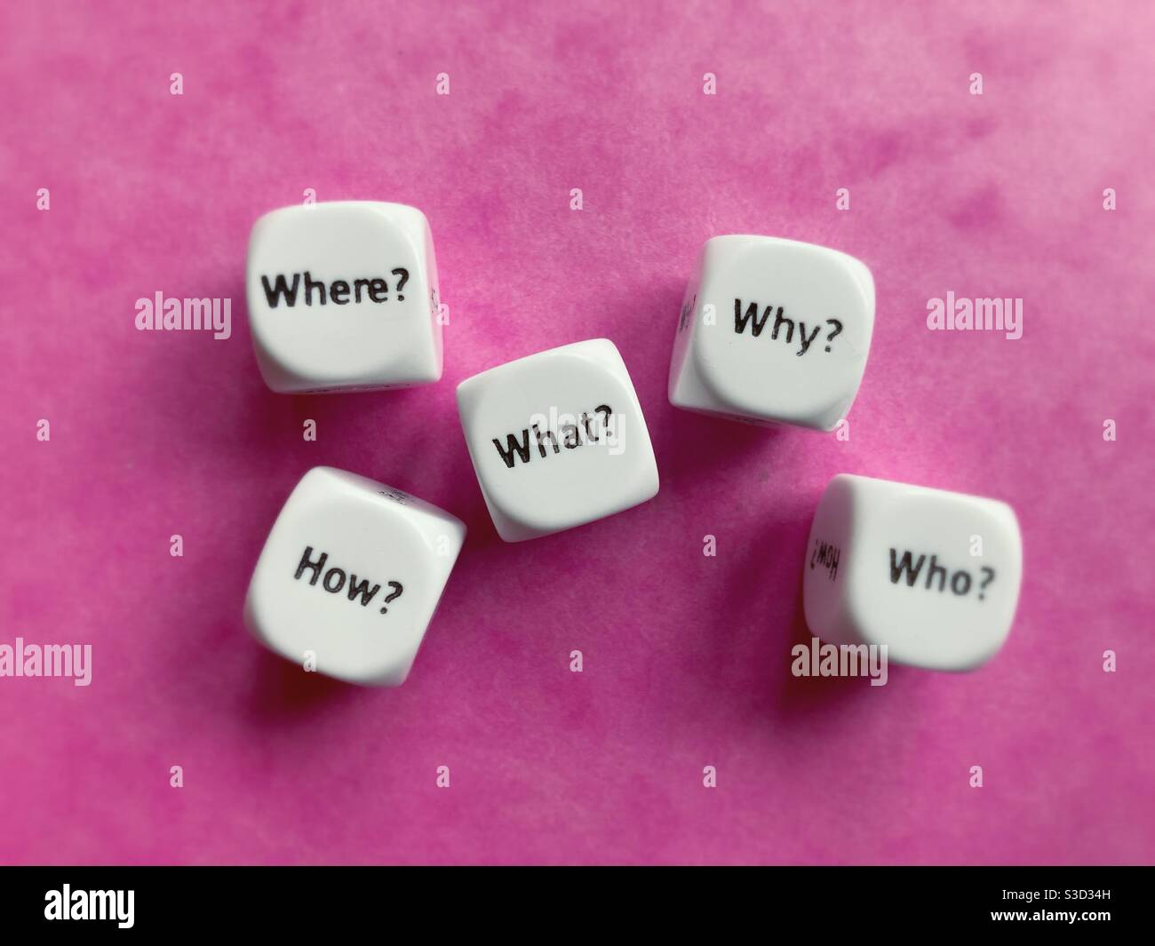 Five Dice with the Questions where, what, why, how, who on pink background - Smartphone Captured Stock Image