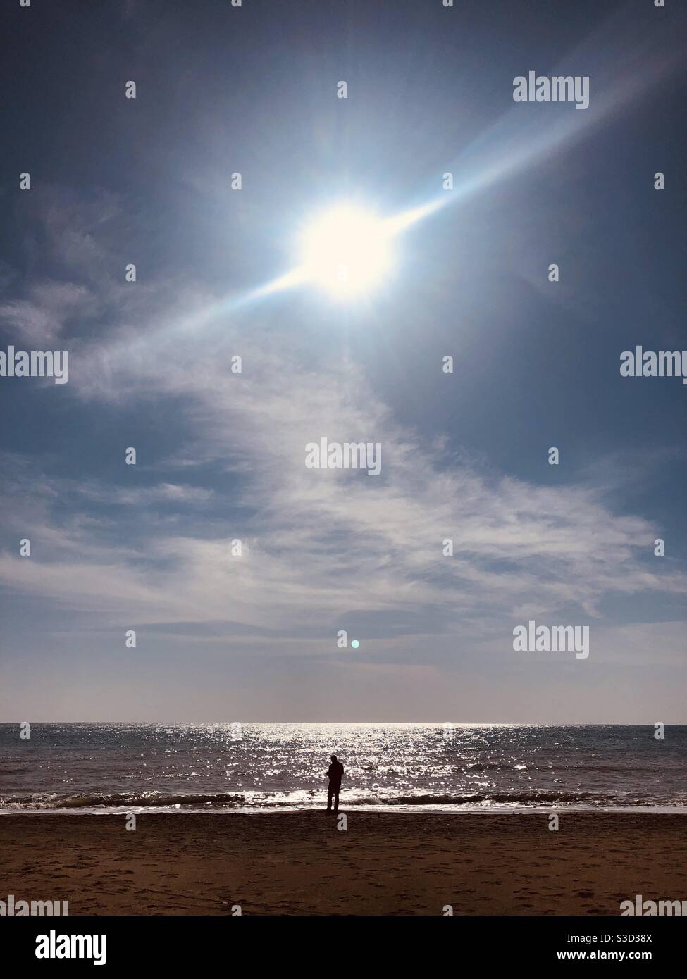 Man standing by the sea on a sunny day - Smartphone Captured Stock Image