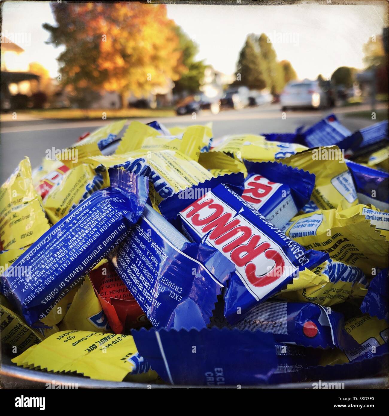 A bowl full of chocolate candy bars ready for trick or treat.  Brand name bars included are Butterfingers and Crunch. Stock Photo