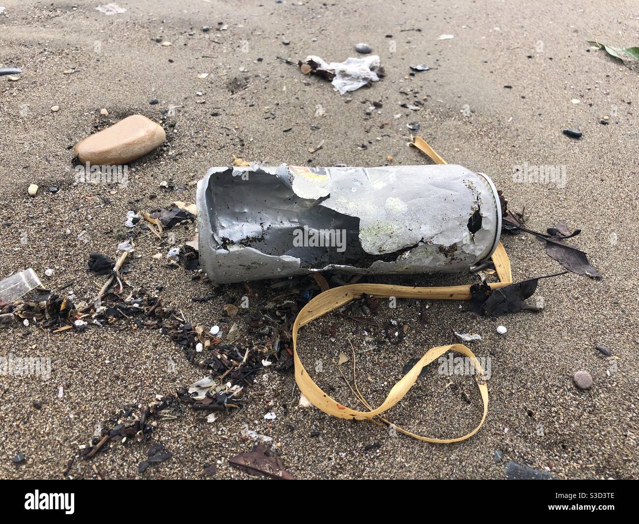 Decayed beer can left on a beach causing pollution - Smartphone Captured Stock Image