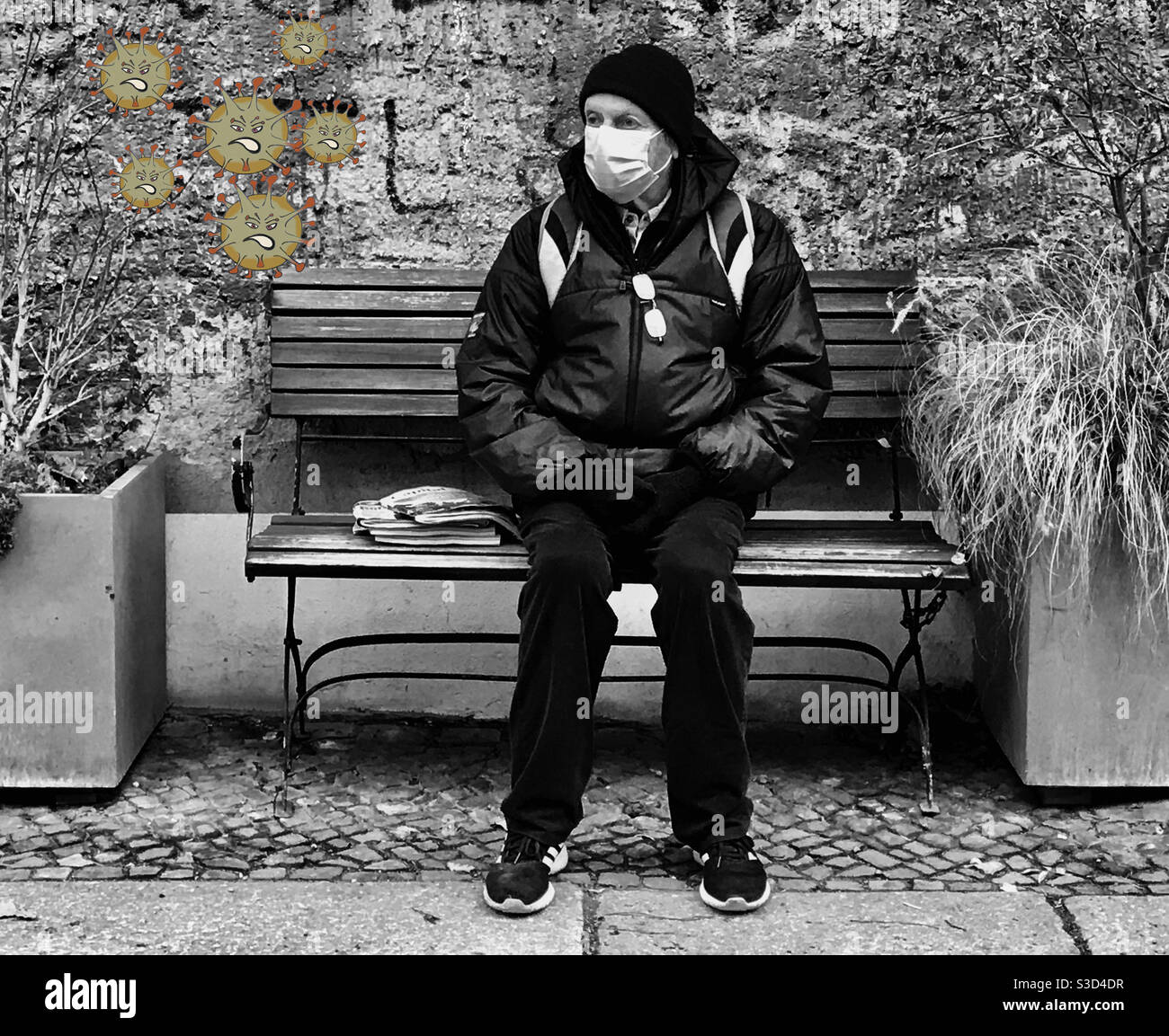 Elderly man wearing face mask sitting on a bench with coronavirus cloud during COVID-19 pandemic - Smartphone Captured Stock Image