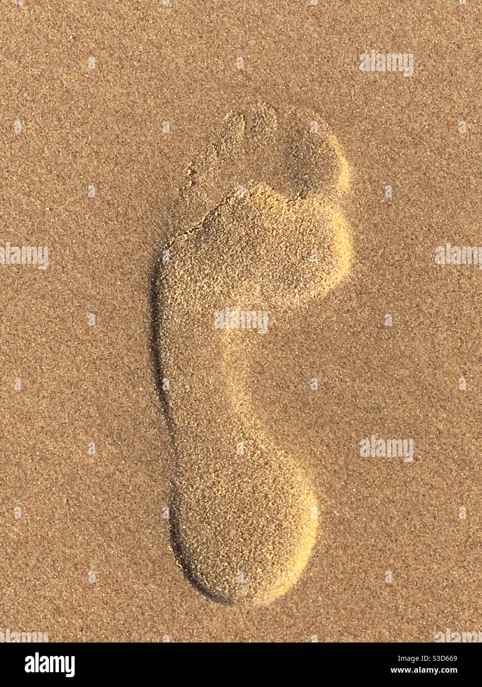 Footprint in the sand, left foot. Optical illusion looks raised when actually imprinted - Smartphone Captured Stock Image