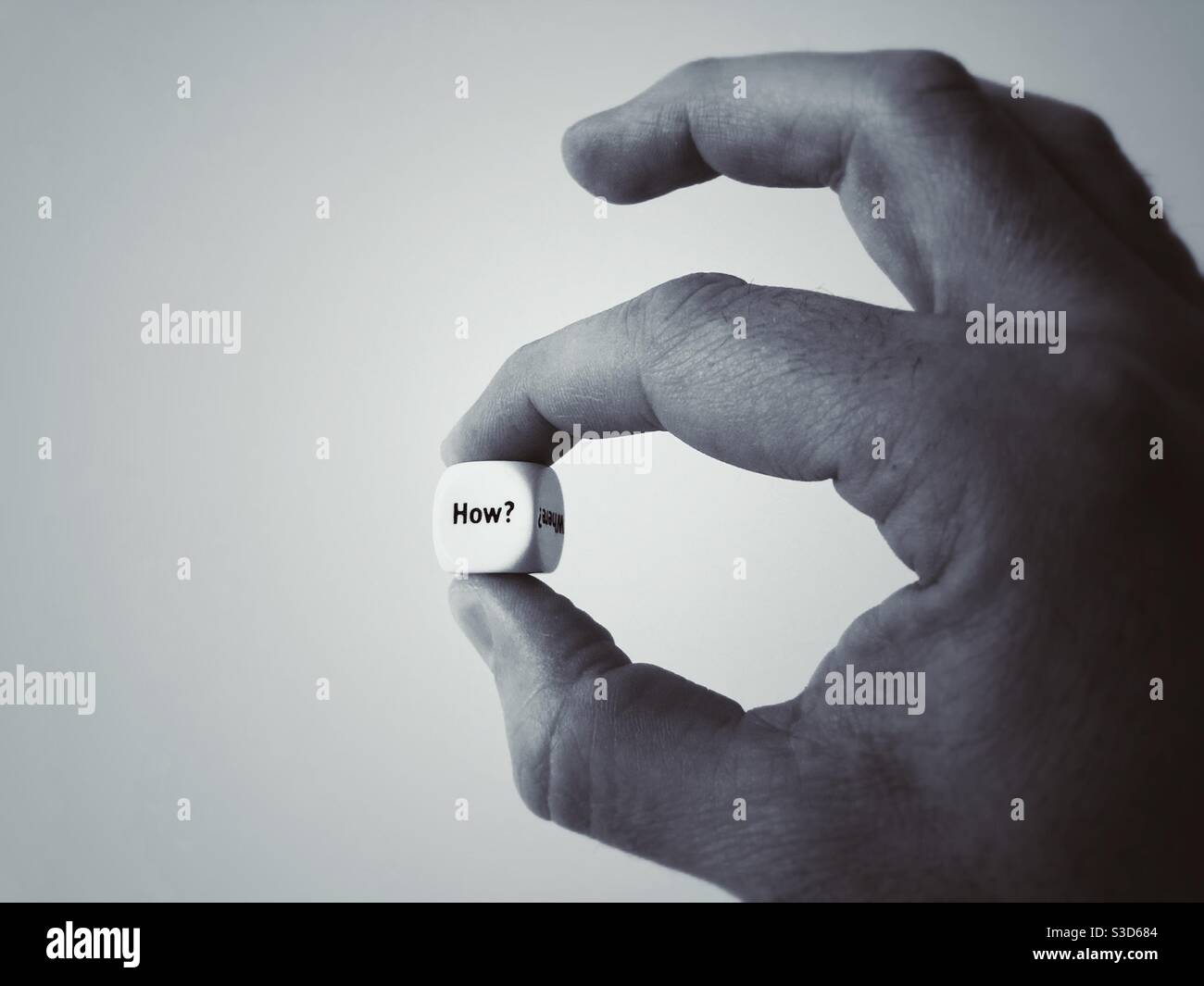 A die with the Question How in a man’s hand - Smartphone Captured Stock Image