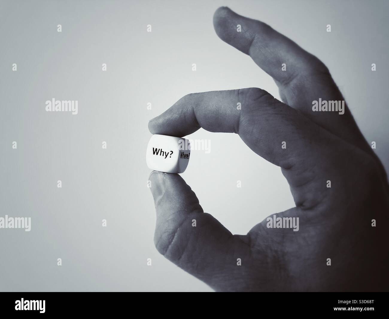A die with the Question Why in a man’s hand - Smartphone Captured Stock Image