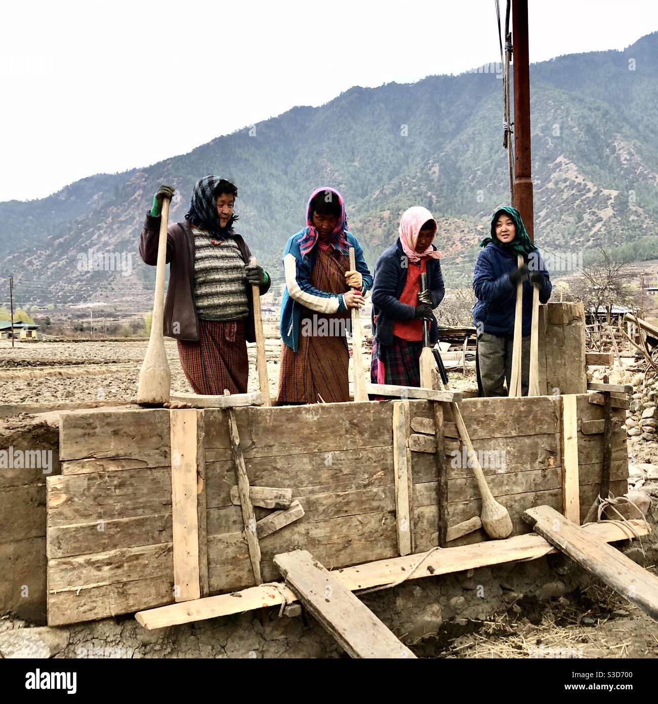 Bhutanese women working building a rammed earth wall at a construction site - Smartphone Captured Stock Image
