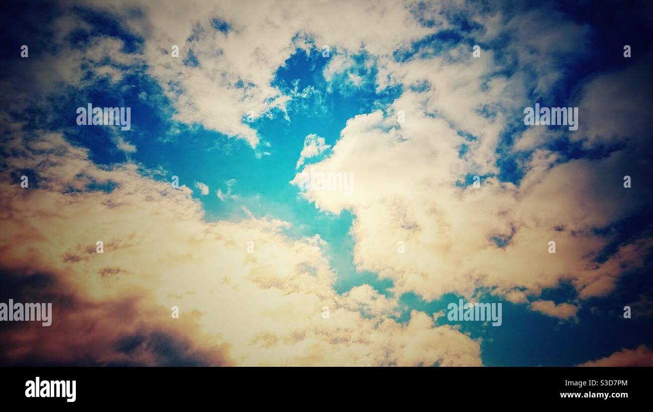 A photograph of a vivid blue cloudy sky with bright sunlight Stock ...