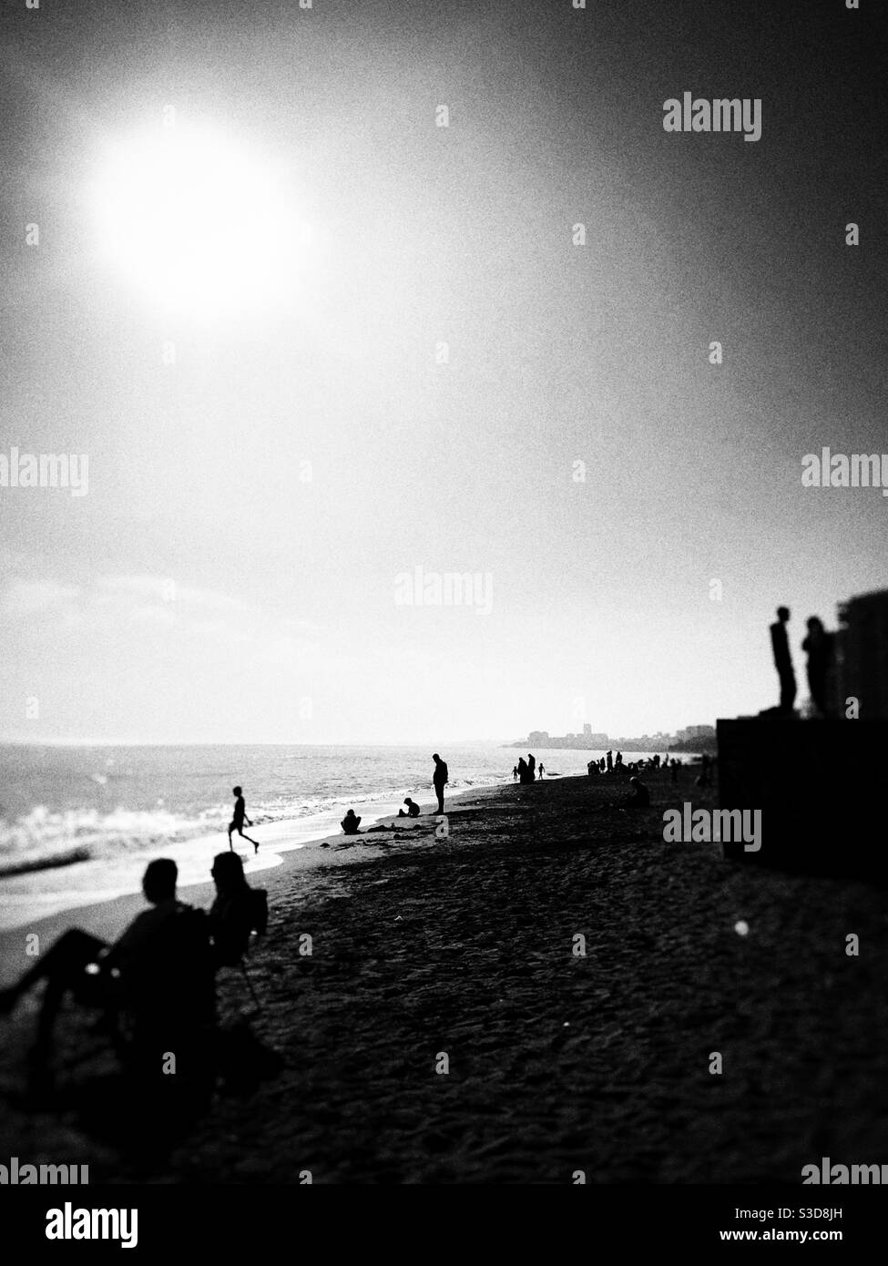 Black and white image of a Crowded beach on a sunny day - Smartphone Captured Stock Image