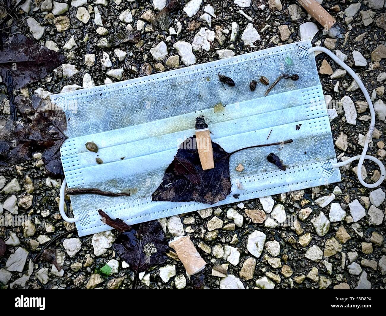 Used face mask left on the street Stock Photo