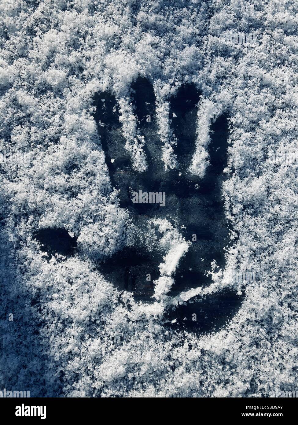 A handprint in the snow on a cold winters day Stock Photo