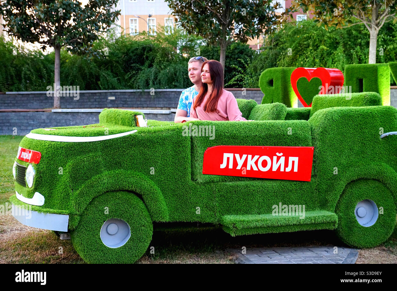 A guy and a girl are posing for a photo in an unusual car - Smartphone Captured Stock Image