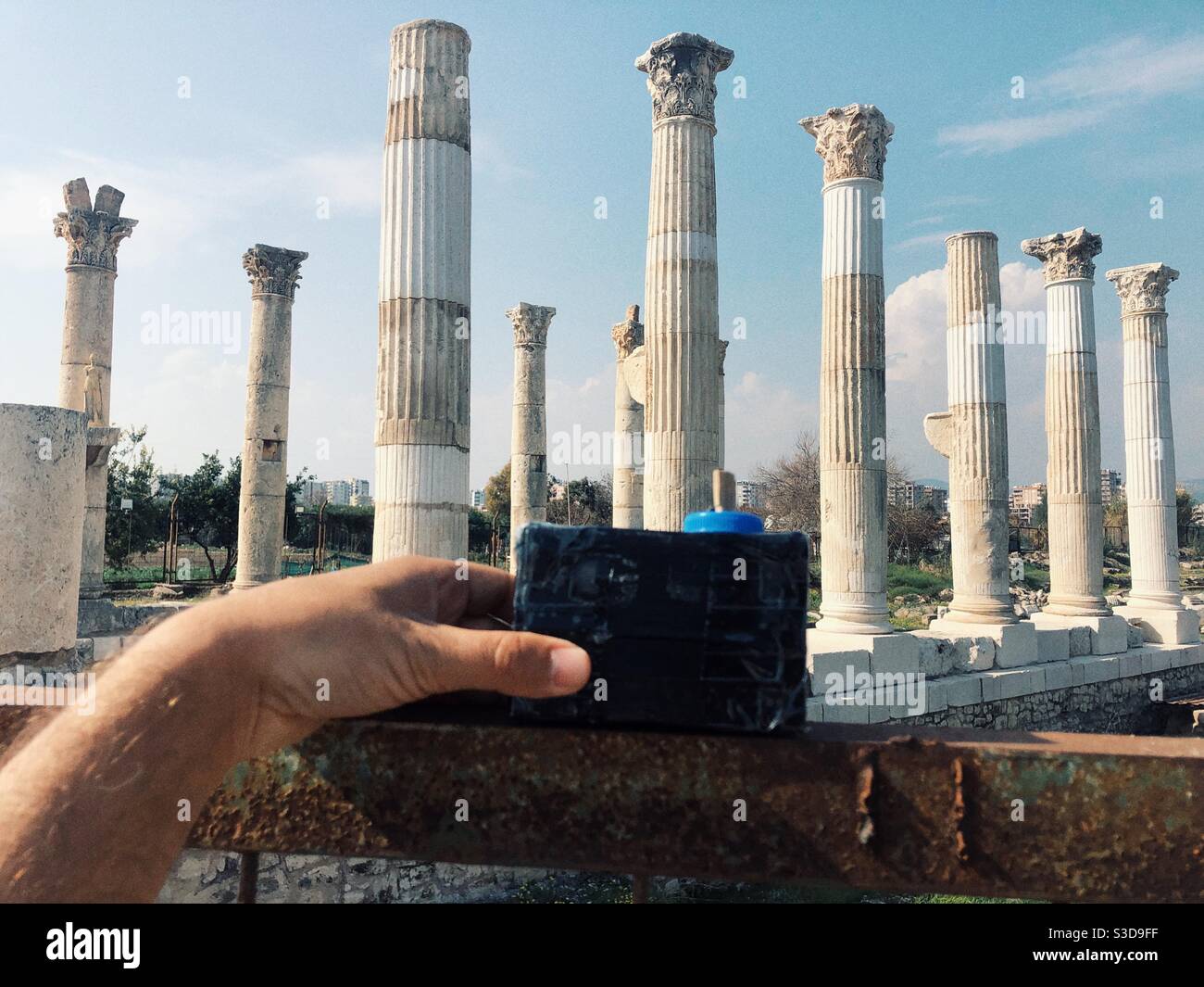 Hand of a person taking a photo of ancient Roman columns in Mersin Turkey - Smartphone Captured Stock Image