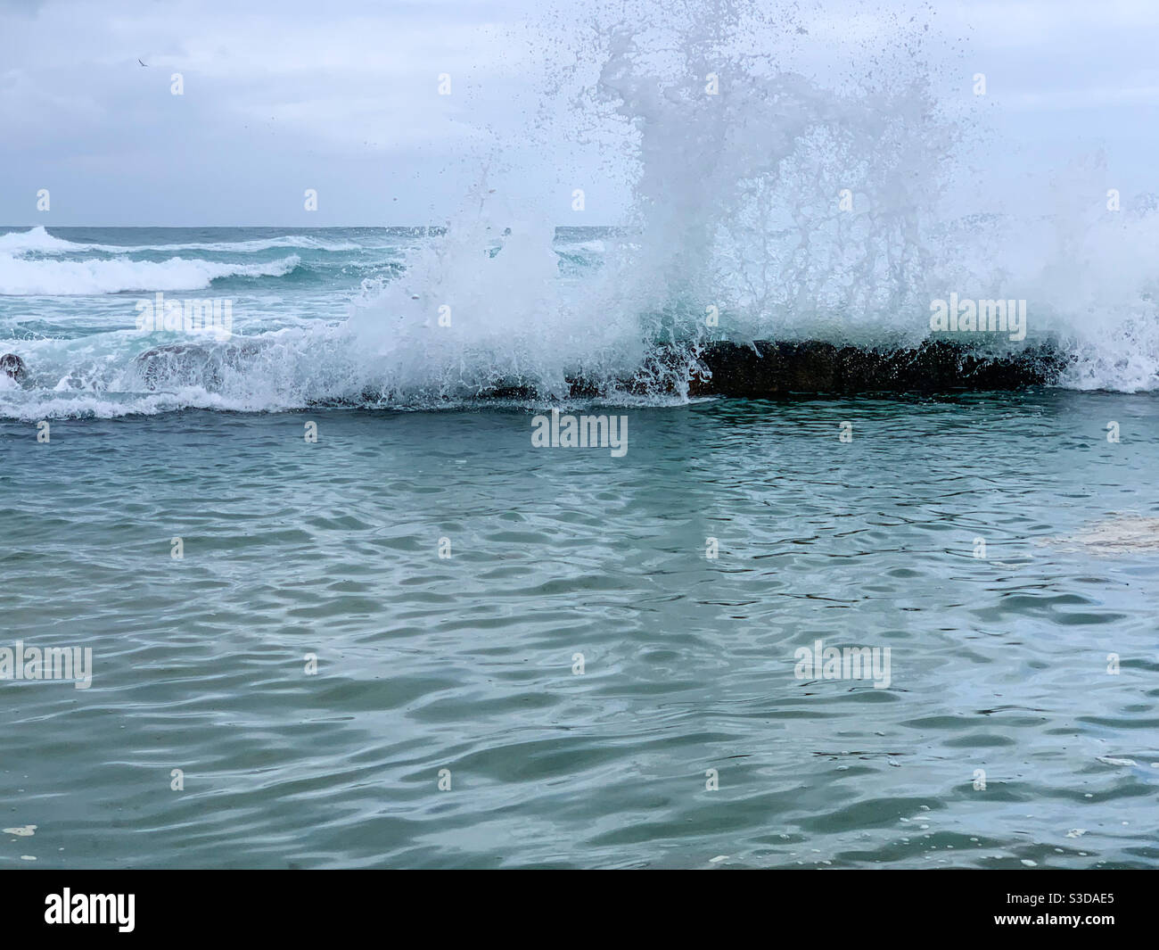 Surf crashing over the edge of the Rock pool - Smartphone Captured Stock Image
