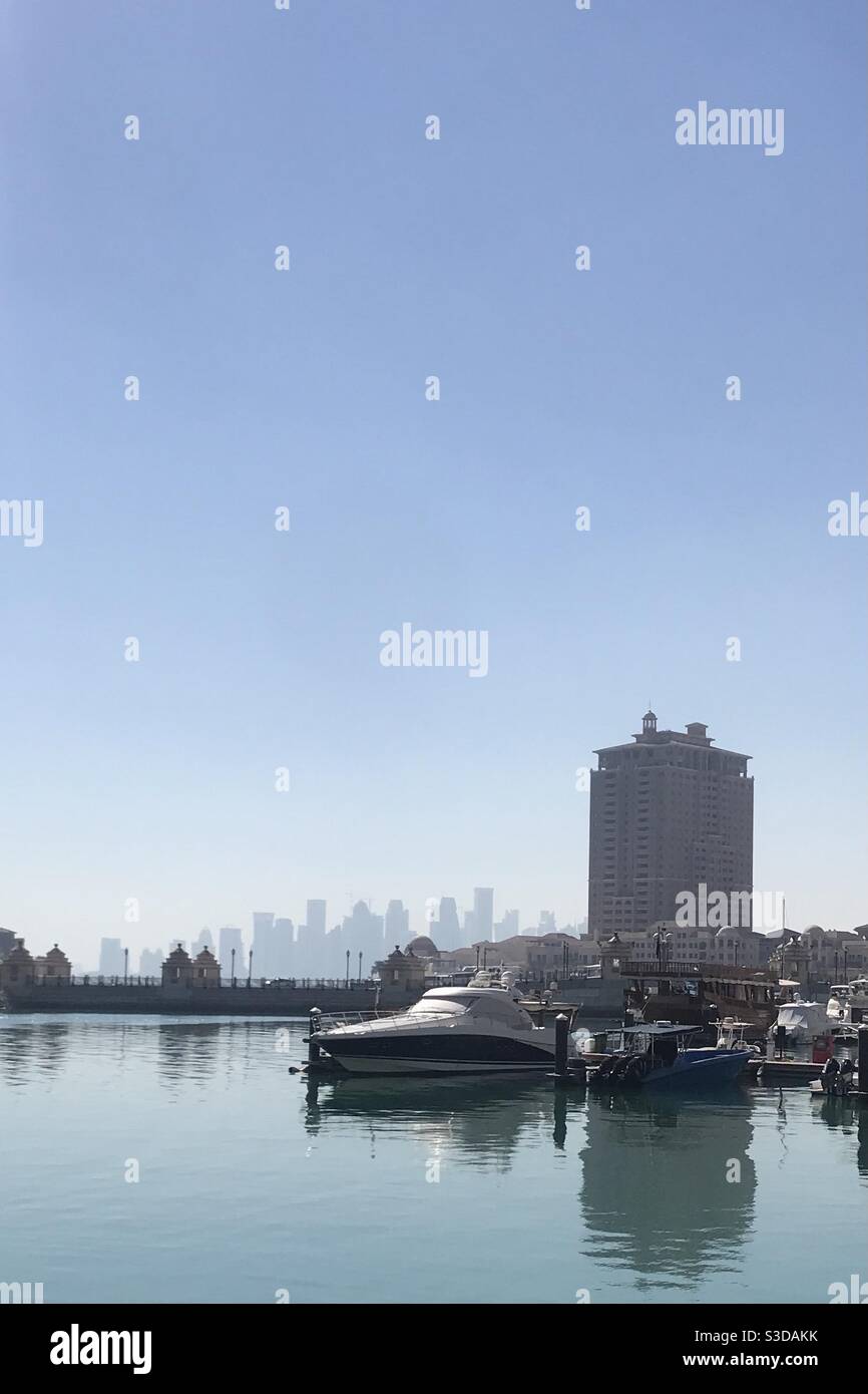 Porto Arabia on the artificial island of The Pearl, Qatar, with a view of the Doha skyline in the background - Smartphone Captured Stock Image