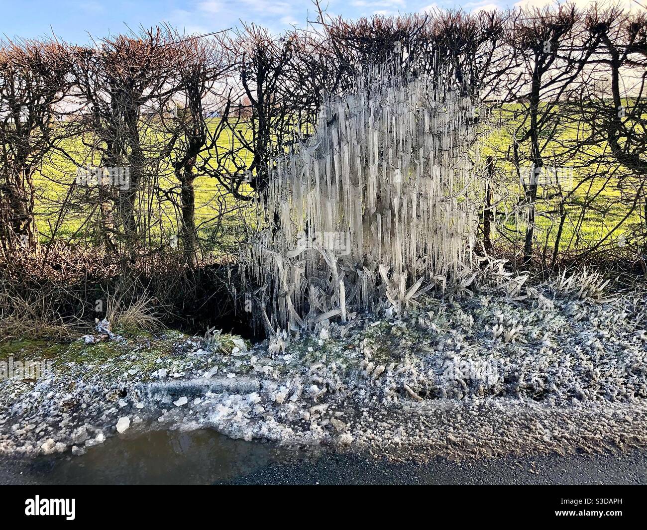 Frozen water spray caused by passing cars Stock Photo