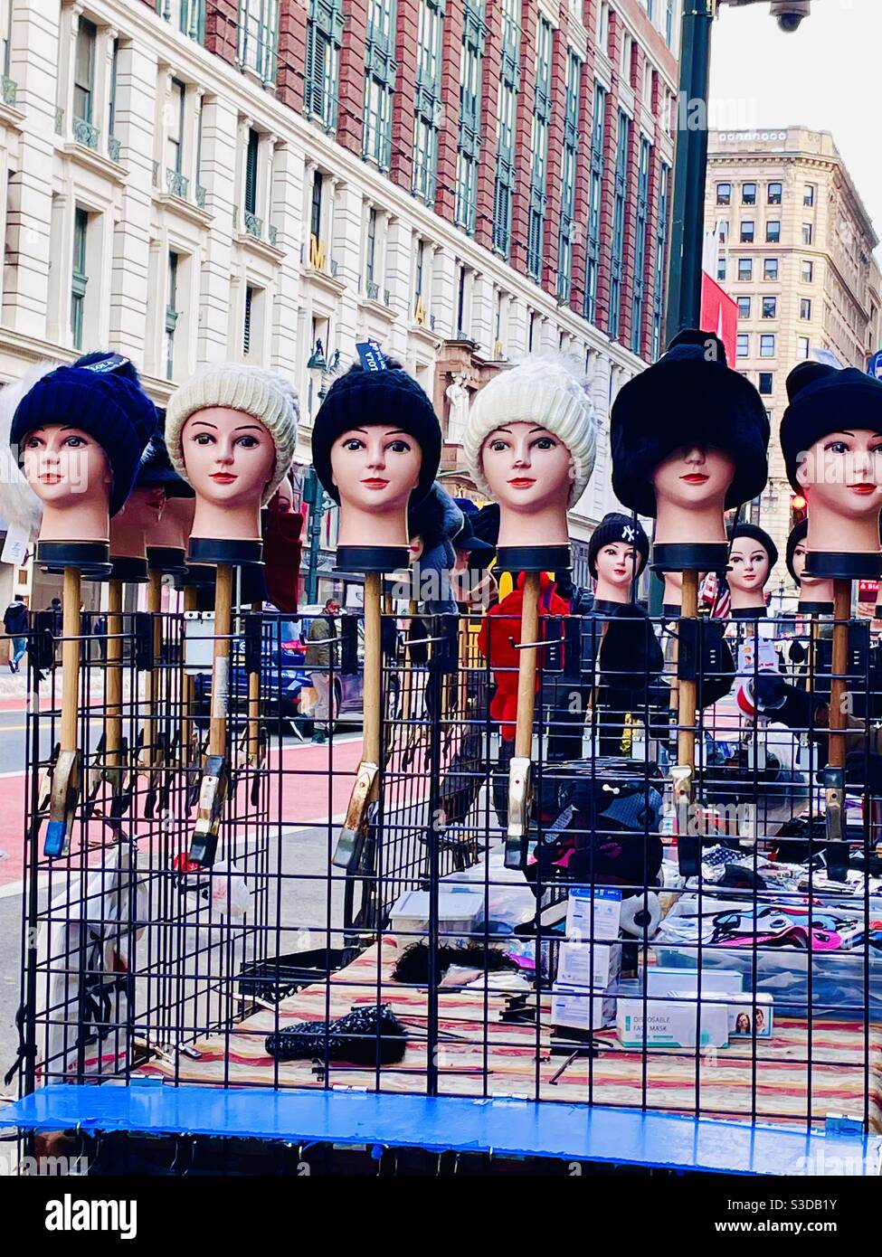 A row of mannequin heads model knit winter hats on a street vendor stall on 34th St. in Midtown Manhattan, New York, USA - Smartphone Captured Stock Image