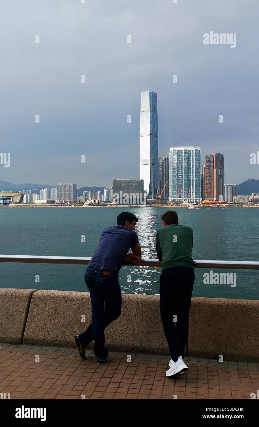 Xpats enjoying the Victoria harbour views from the promenade by the central piers in Hong Kong. - Smartphone Captured Stock Image