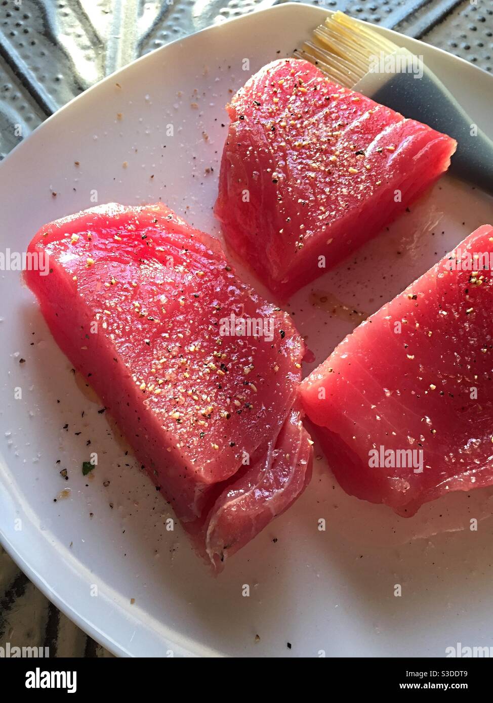 Close up of raw fresh seasoned tuna steaks on a plate - Smartphone Captured Stock Image