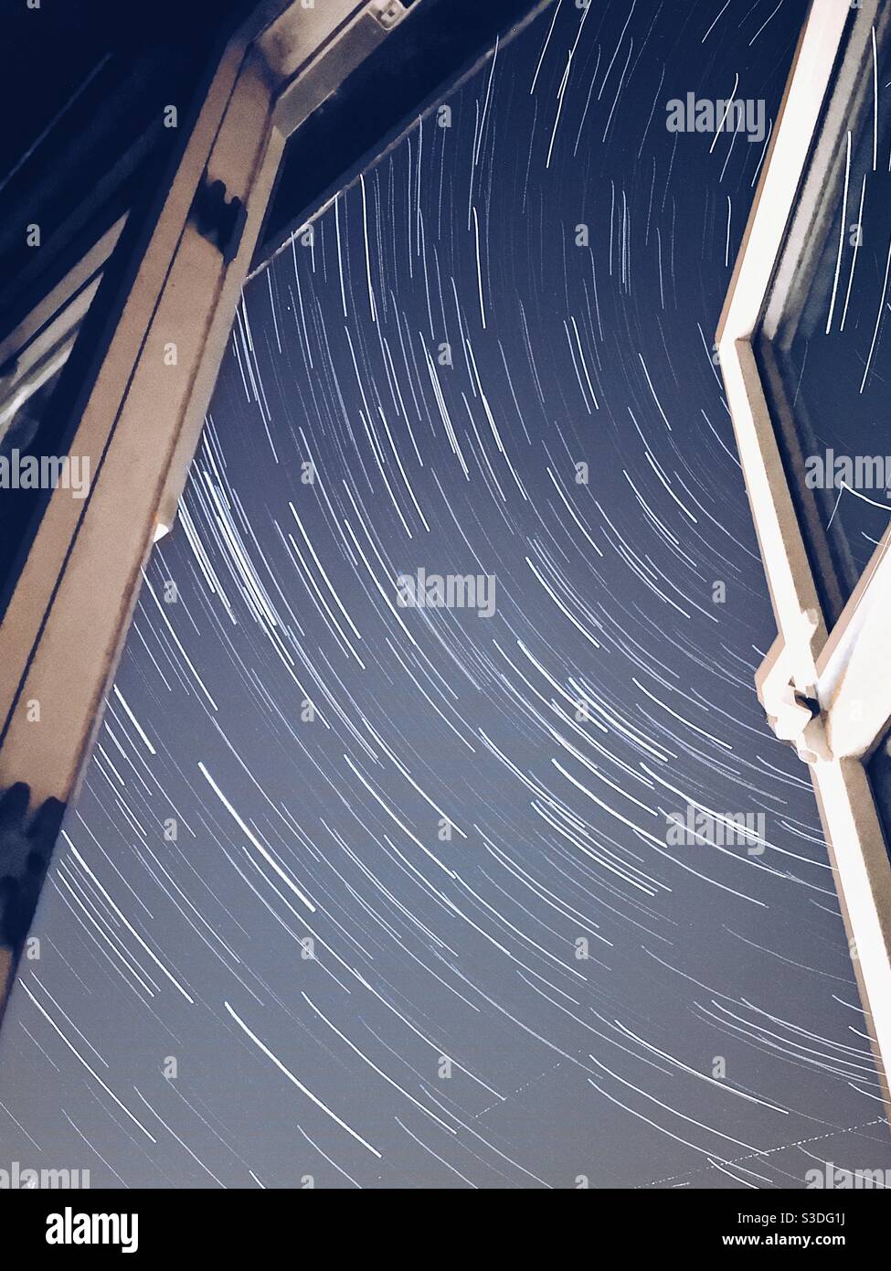 Northern hemisphere star trails through a window - Smartphone Captured Stock Image