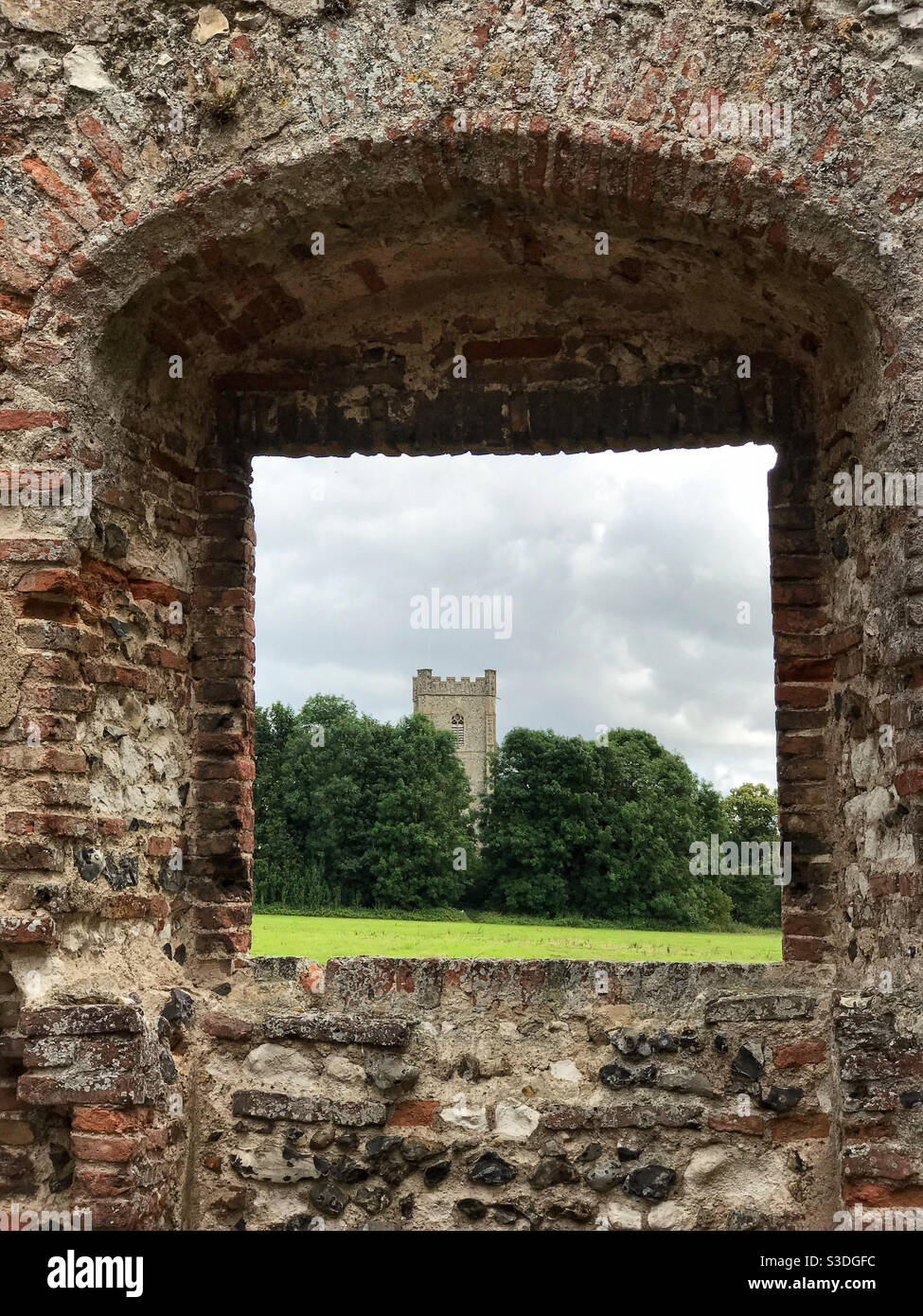 St. James the Great Church, framed through the entrance to Castle Acre Priory. Near Swaffham, Norfolk, England. - Smartphone Captured Stock Image