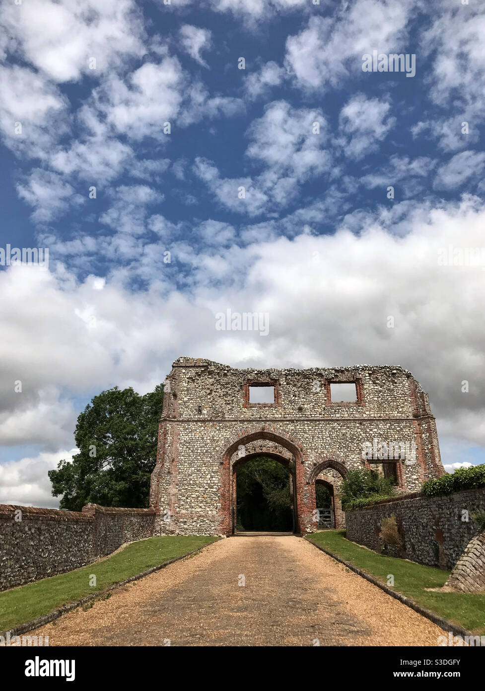 The gatehouse at Castle Acre Priory, with clouds clearing to reveal a blue sky. Near Swaffham, Norfolk, England. - Smartphone Captured Stock Image