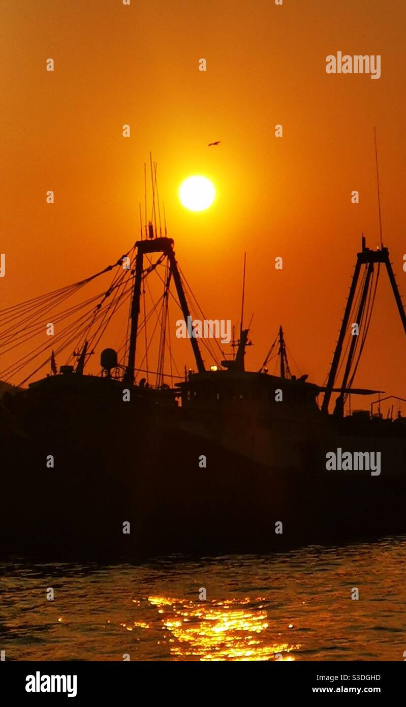 Sunset over a fishing boat at the Aberdeen port in Hong Kong. Stock Photo