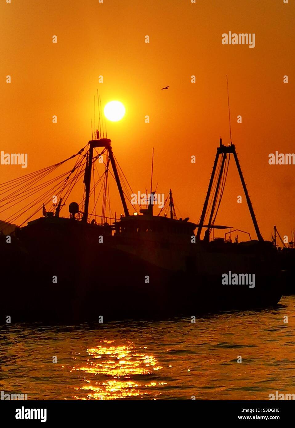 Sunset over a fishing boat at the Aberdeen port in Hong Kong. Stock Photo