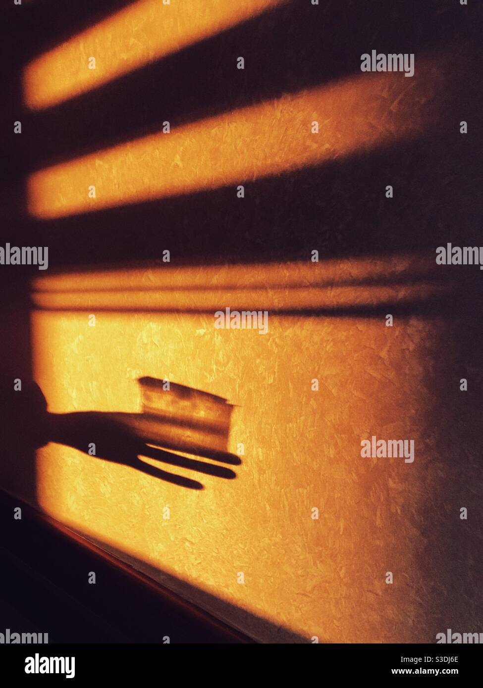 Shadow of a hand on a sunlit wall - Smartphone Captured Stock Image