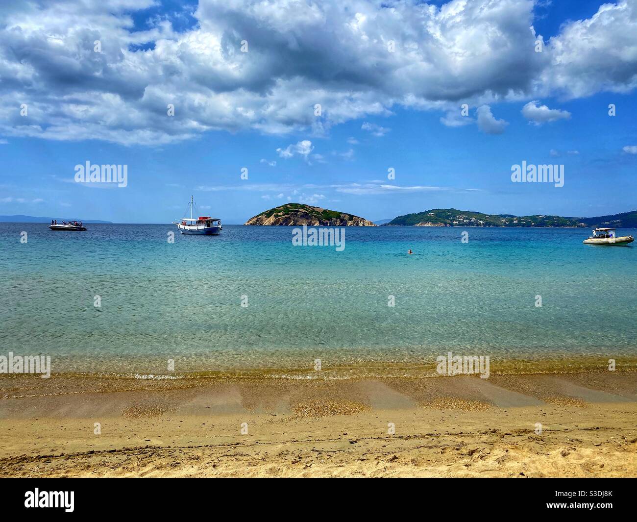 Beach with boats at uninhabited Tsougrias island near Skiathos in Greece. - Smartphone Captured Stock Image