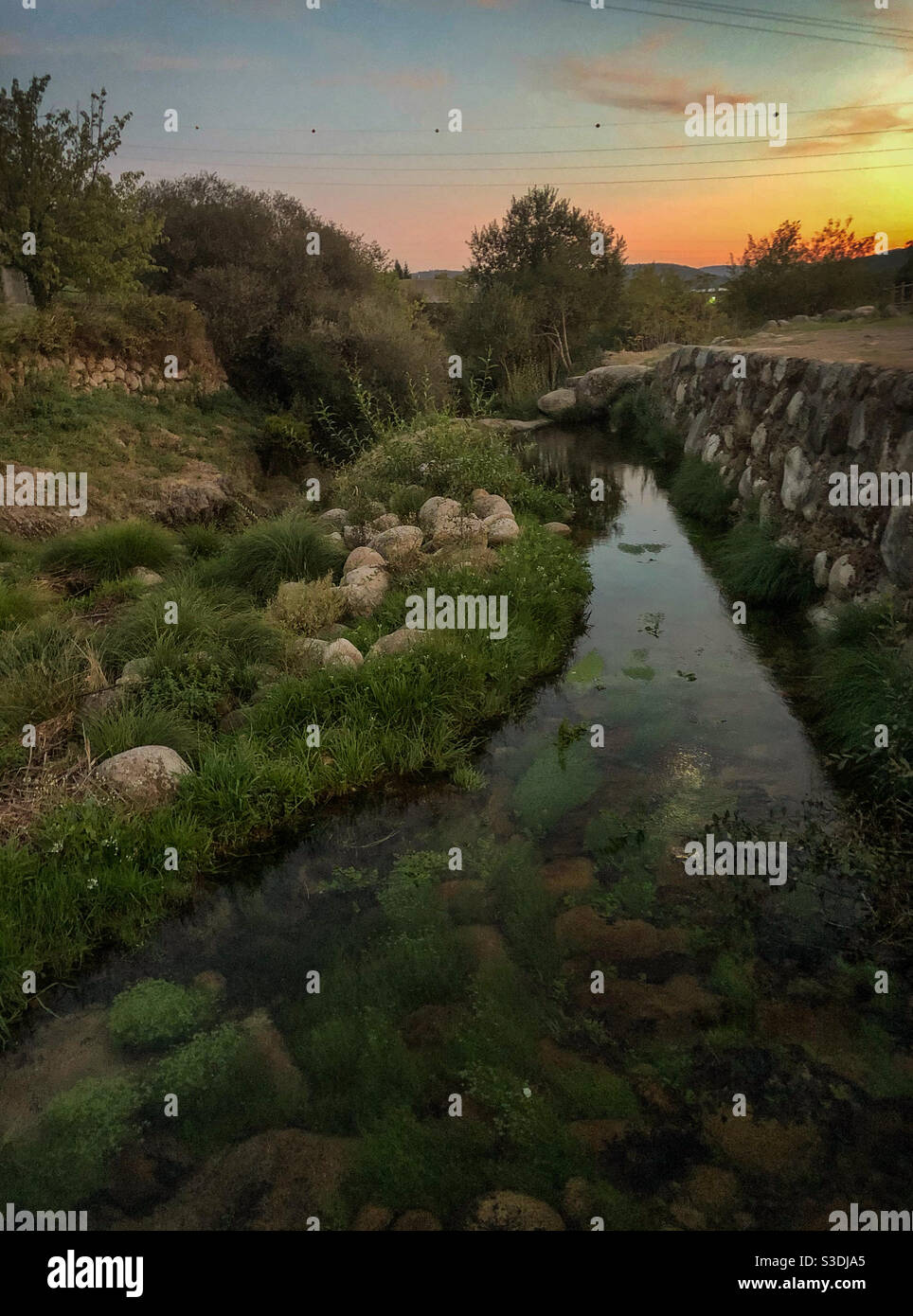 Stream next to stone wall at sunset - Smartphone Captured Stock Image