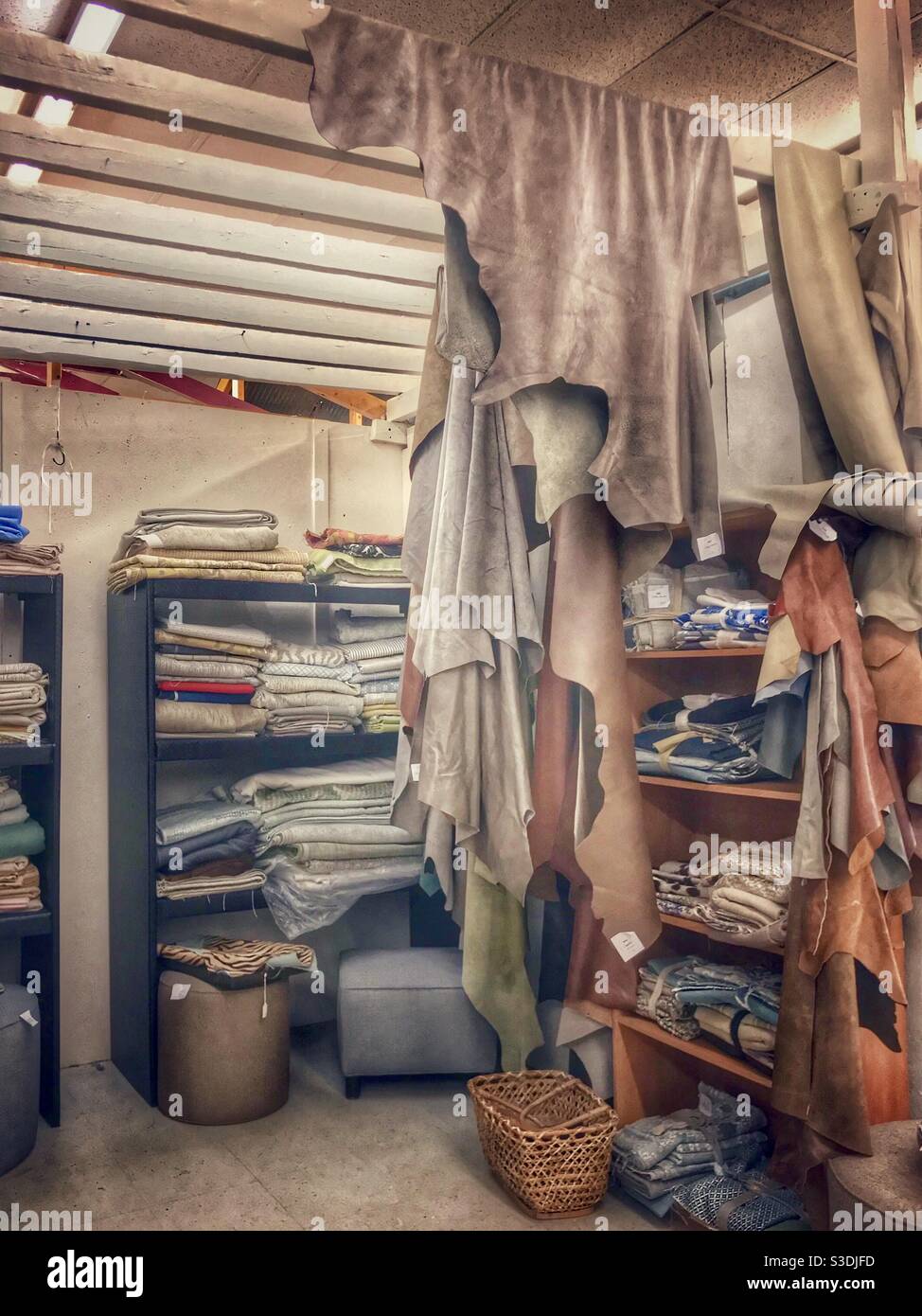 Dyed leather skins, scraps, and fabric for sale in antique mall display - Smartphone Captured Stock Image
