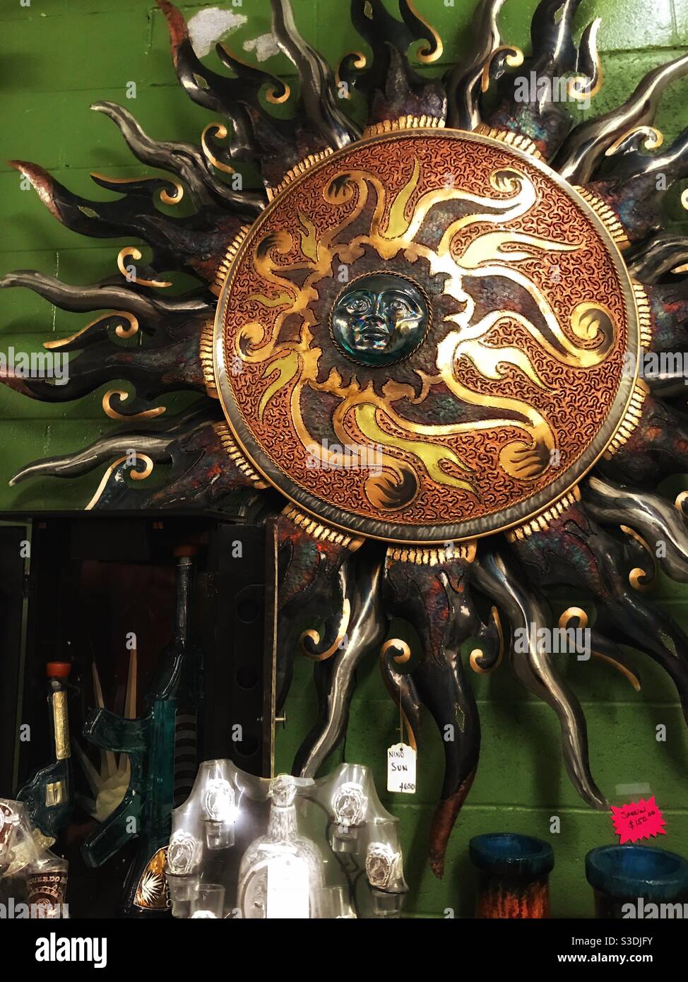 Ethnic celestial sunburst wall art on display in antique mall - Smartphone Captured Stock Image