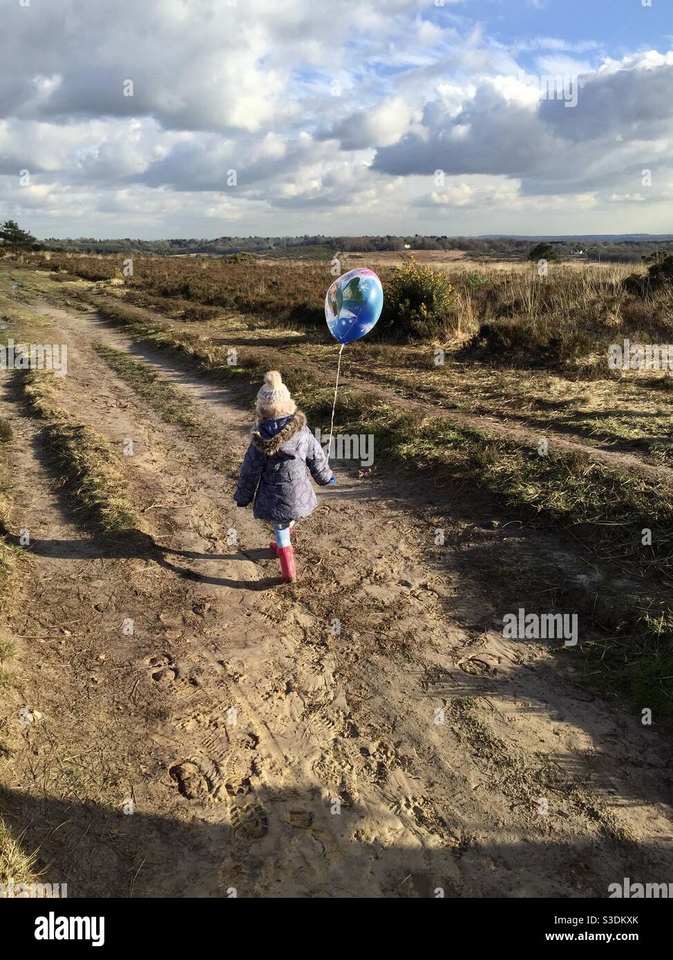 Child walking with Elsa balloon Stock Photo