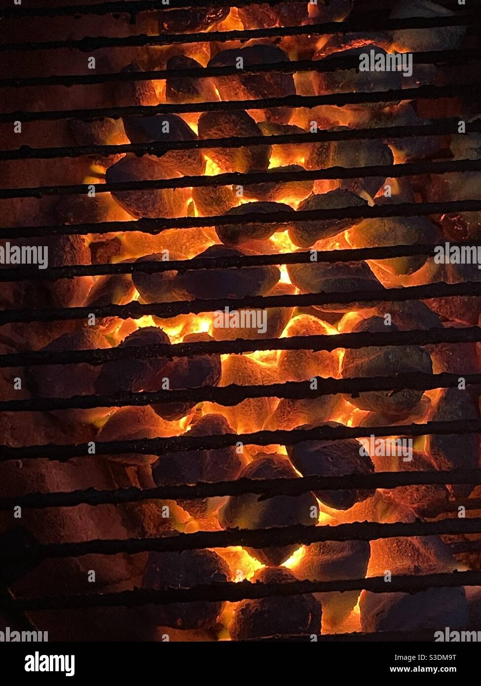 Charcoal glowing orange under a dirty grill grate Stock Photo Alamy