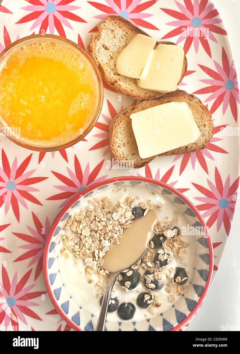 Yummy breakfast with fresh orange juice, oat flakes, bread and butter Stock Photo